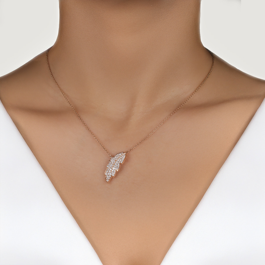 Rose gold necklace with a diamond pendant on a mannequin.