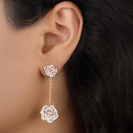 Close-up of a woman's ear wearing a pair of rose gold and silver earrings.