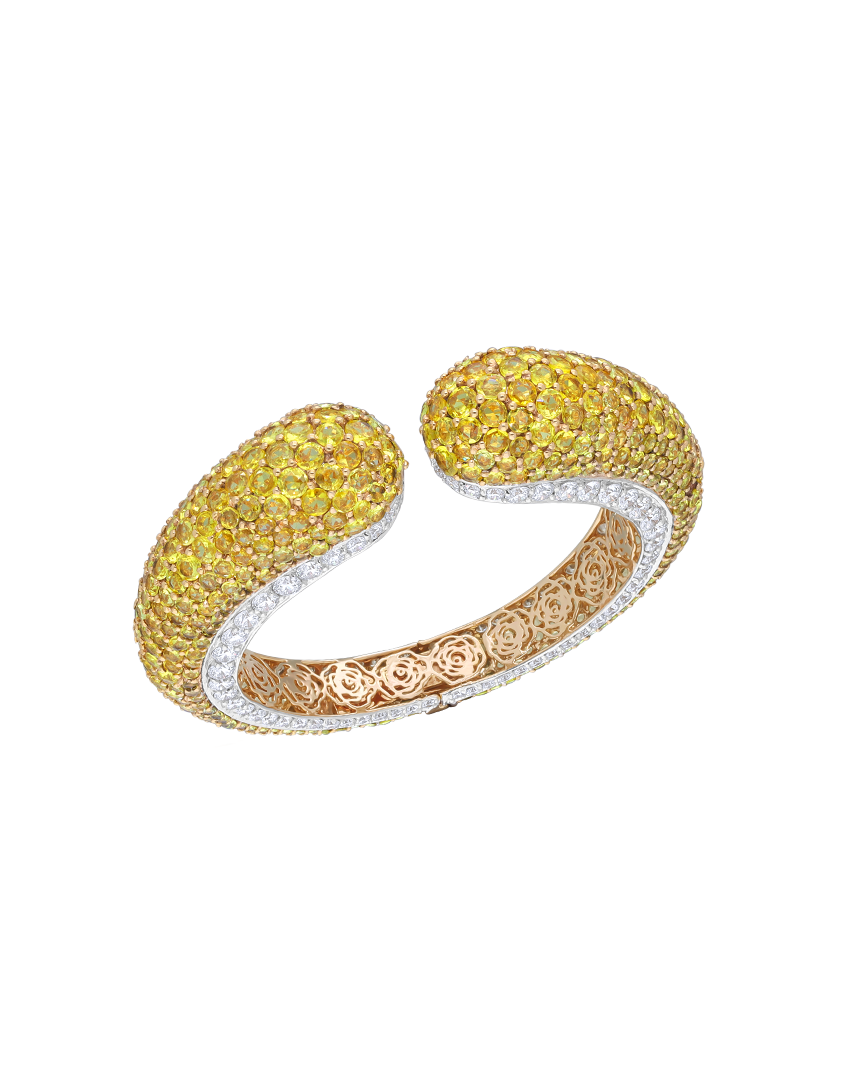 Gold and silver bracelet with yellow gemstones on a white background