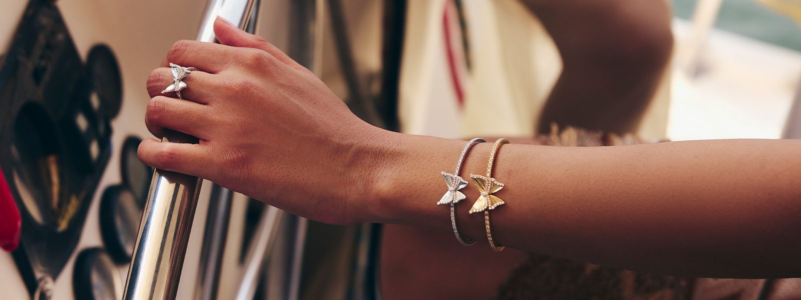 Hand wearing a ring and bracelets on a blurred background