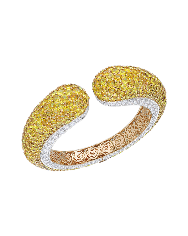 Gold and silver bracelet with yellow gemstones on a white background
